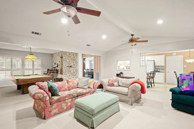 a living room with furniture ceiling fan and a window
