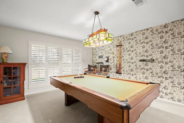 a room with pool table and windows