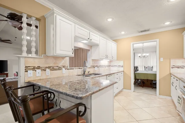 a kitchen with granite countertop a sink stove and cabinets