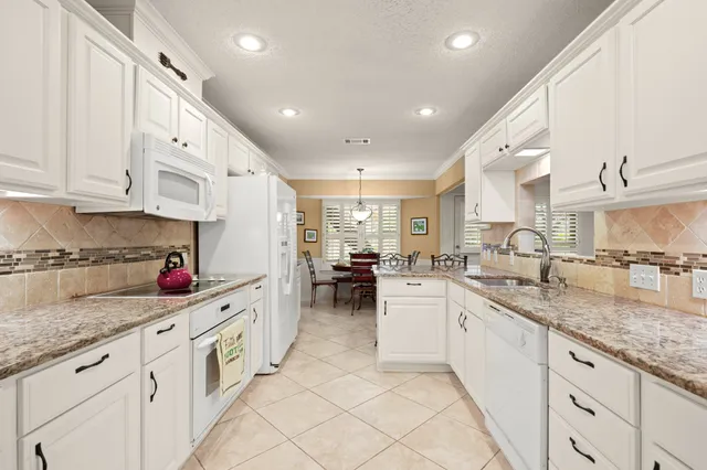 a kitchen with lot of counter top space a sink cabinets and appliances
