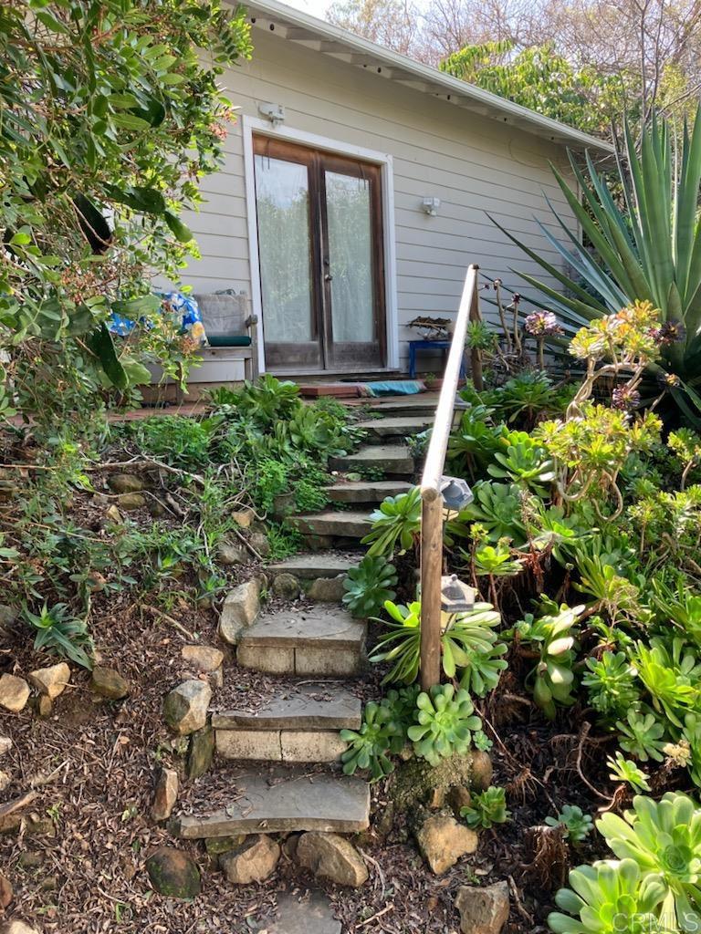 18525 Aliso Canyon Road Rancho Santa Fe, CA 92091 - Photo 10 of 16 a view of a house with a yard and plants