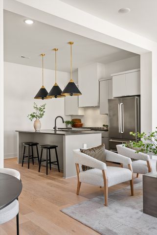 a kitchen with stainless steel appliances a sink and a chandelier