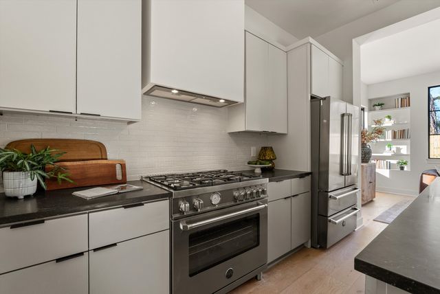 a kitchen with stainless steel appliances granite countertop a sink and stove