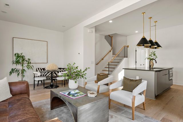a living room with furniture kitchen view and a potted plant