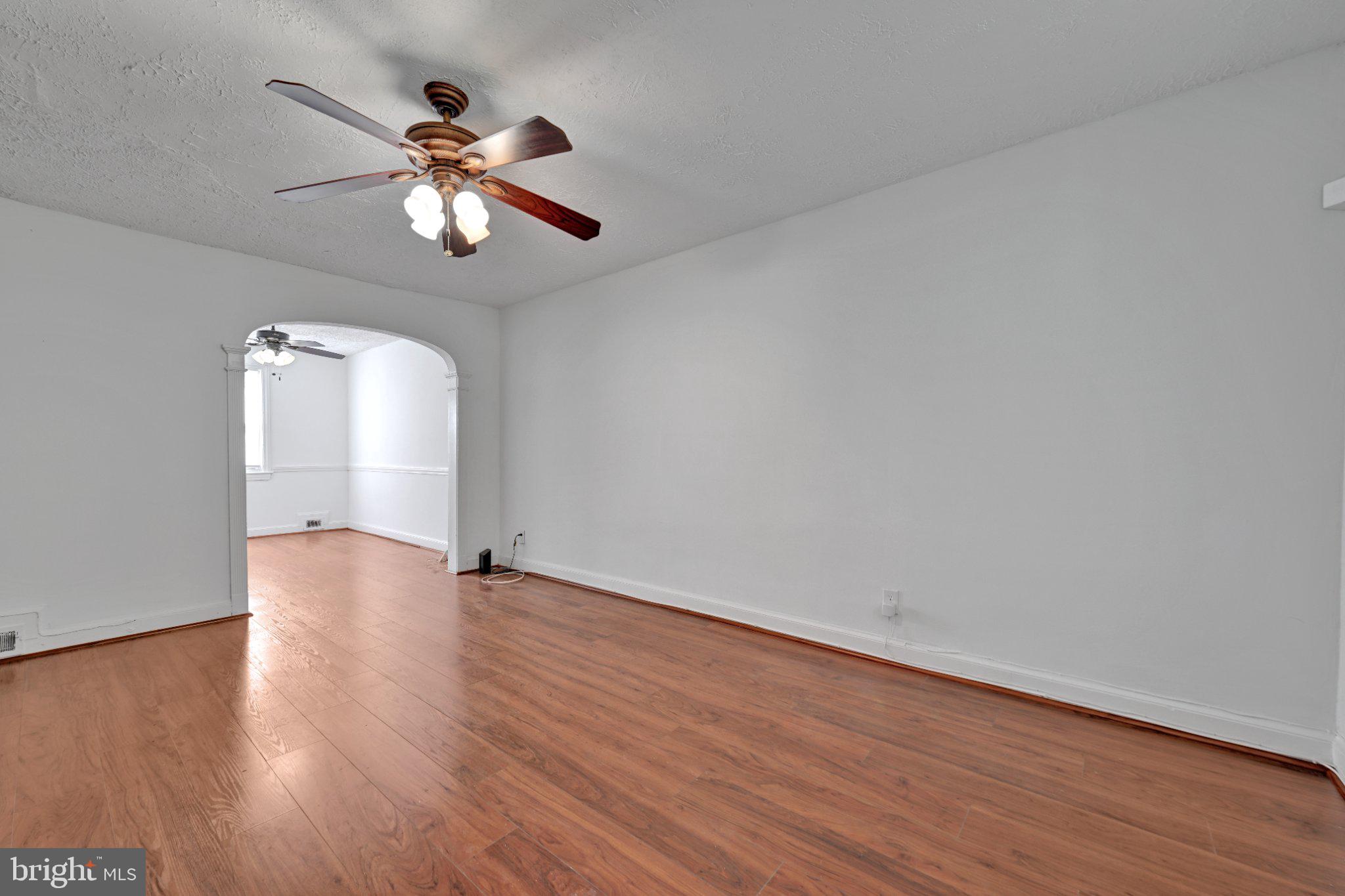 4607 North Capitol Street Northeast Washington, DC 20011 - Photo 3 of 25 an empty room with wooden floor chandelier fan and windows