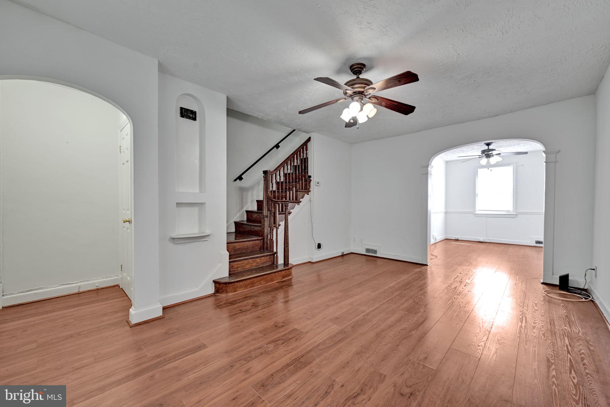 4607 North Capitol Street Northeast Washington, DC 20011 - Photo 6 of 25 an empty room with wooden floor chandelier fan and windows