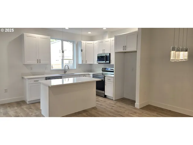 a kitchen with kitchen island sink stove and refrigerator