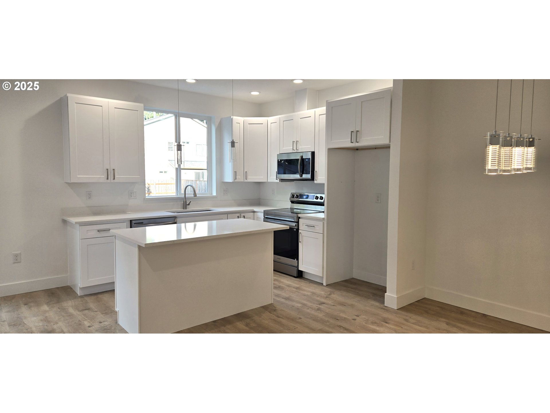 12451 Southeast Harold Street, Unit 1 Portland, OR 97236 - Photo 6 of 21 a kitchen with kitchen island sink stove and refrigerator