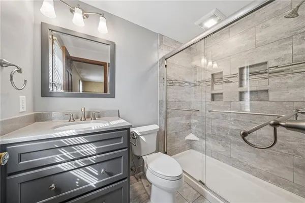 a bathroom with a granite countertop toilet sink and mirror