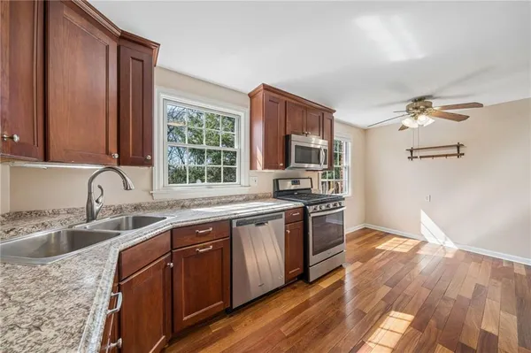 a kitchen with stainless steel appliances granite countertop a sink stove and refrigerator