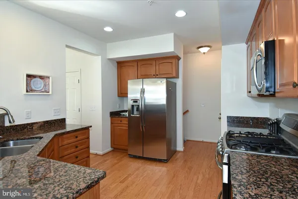a kitchen with stainless steel appliances granite countertop a refrigerator and a sink