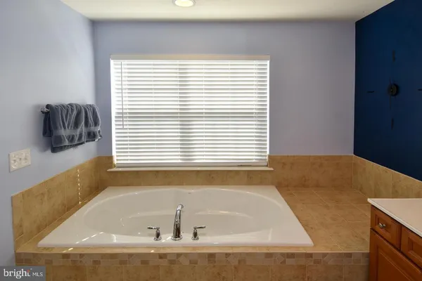 a bathroom with bathtub and next to a window