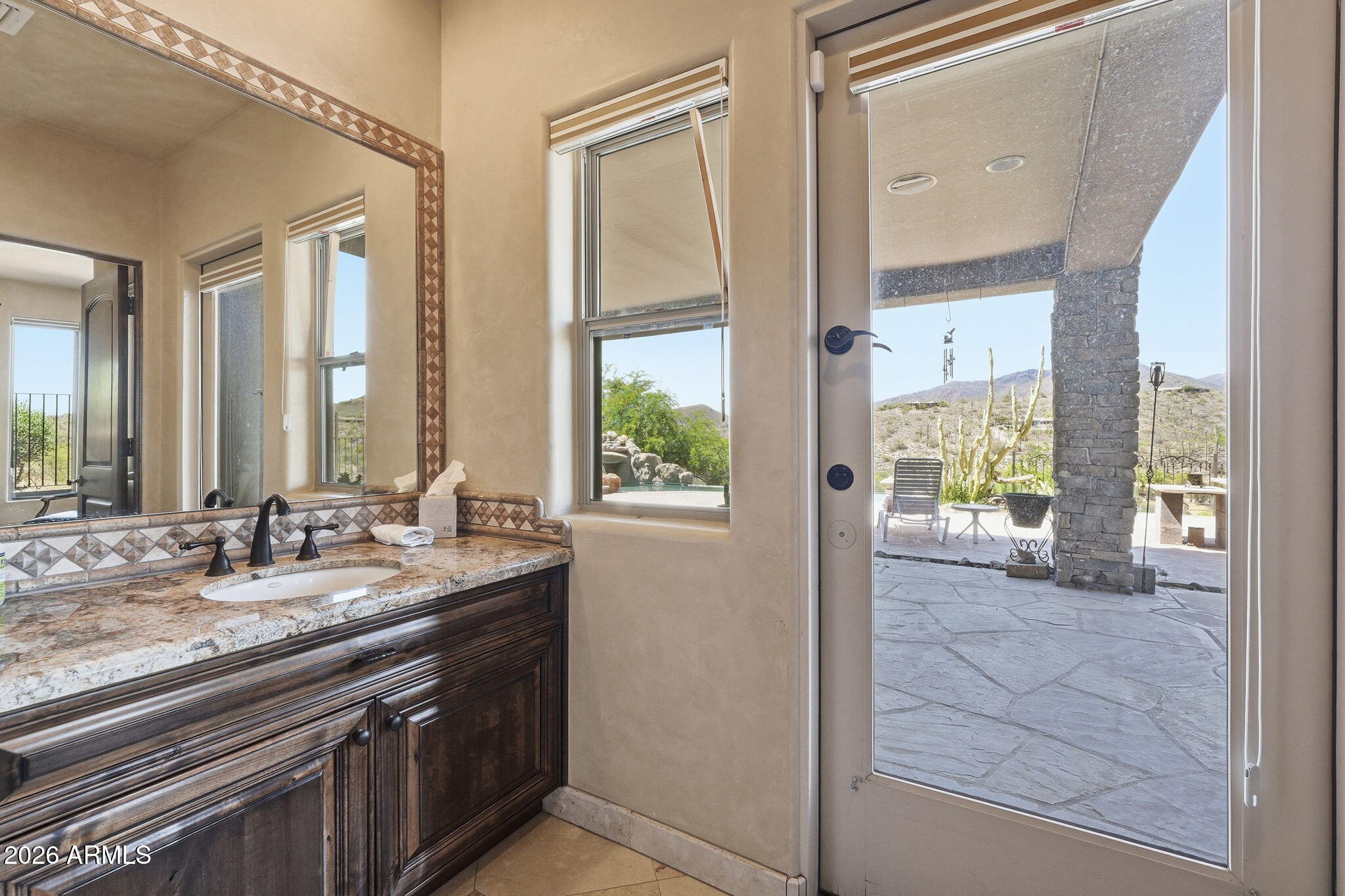 38211 North Sombrero Road Carefree, AZ 85377 - Photo 31 of 50 a bathroom with a granite countertop sink and a large mirror