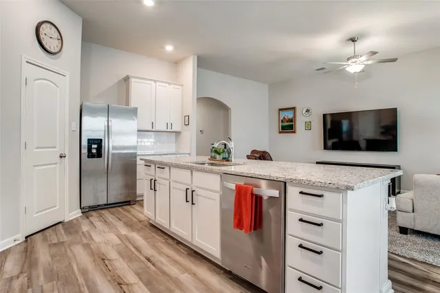 a kitchen with stainless steel appliances granite countertop a stove a sink and a refrigerator