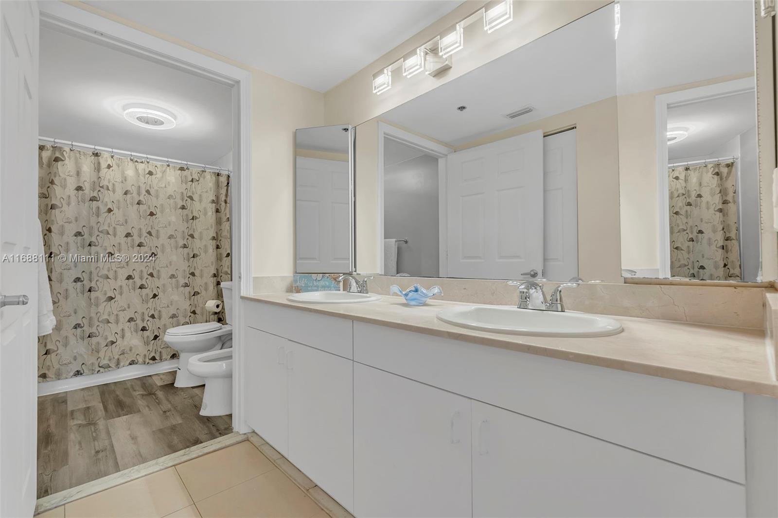 8888 Collins Avenue, Unit 113 Surfside, FL 33154 - Photo 14 of 14 a bathroom with a double vanity sink mirror and shower