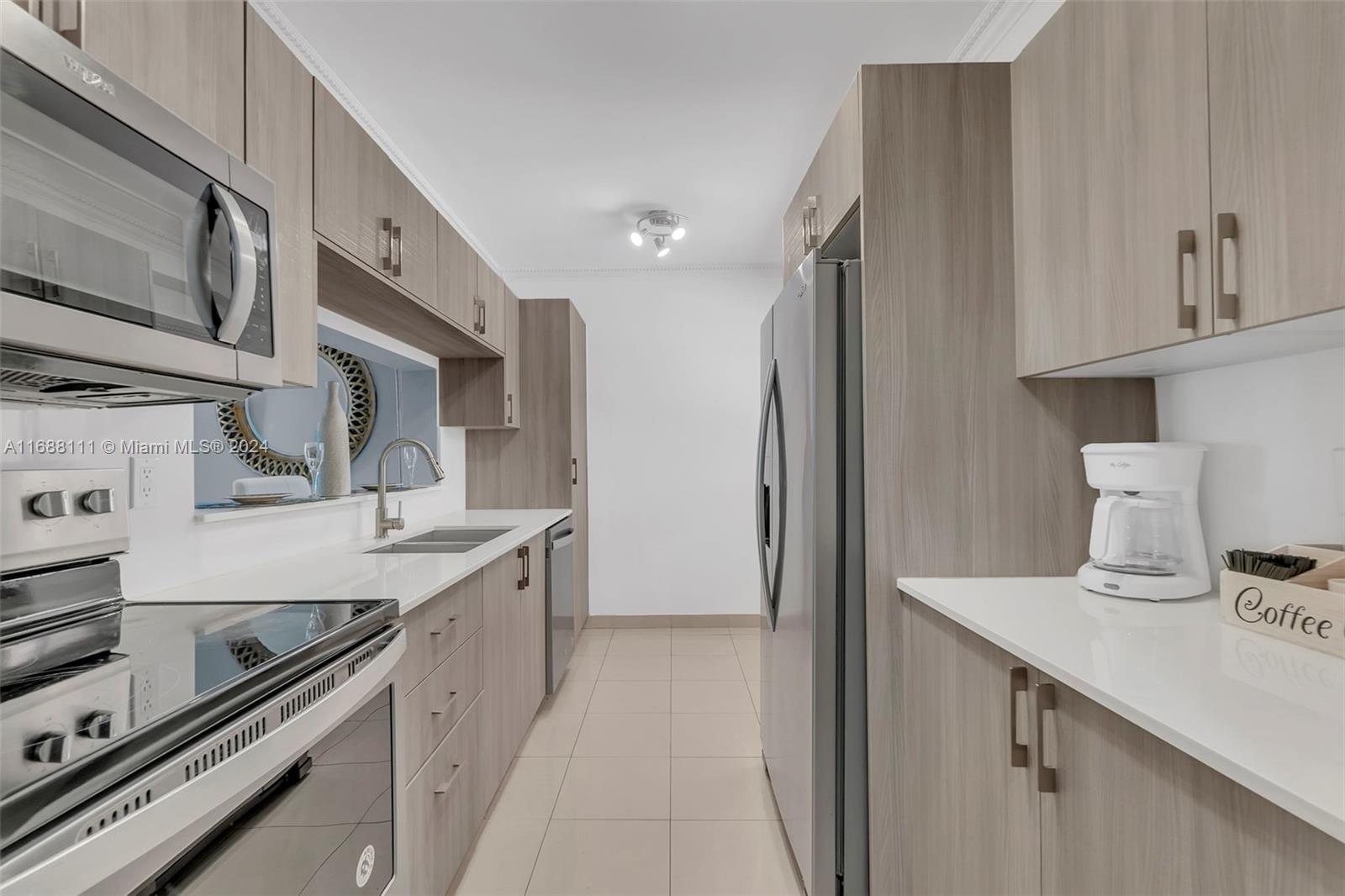 8888 Collins Avenue, Unit 113 Surfside, FL 33154 - Photo 7 of 14 a kitchen with a sink stove and cabinets