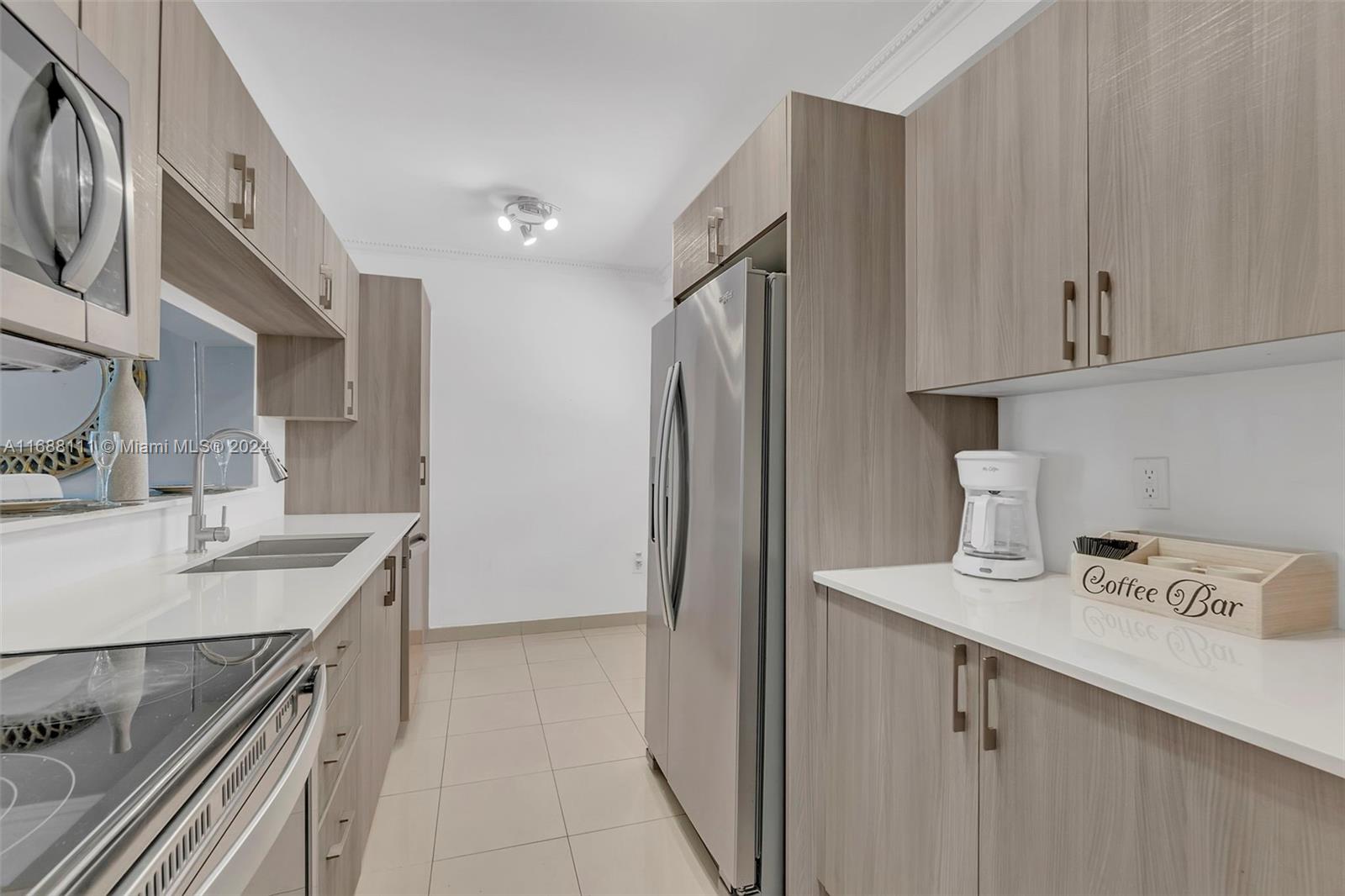 8888 Collins Avenue, Unit 113 Surfside, FL 33154 - Photo 8 of 14 a kitchen with stainless steel appliances granite countertop a sink a refrigerator and a stove