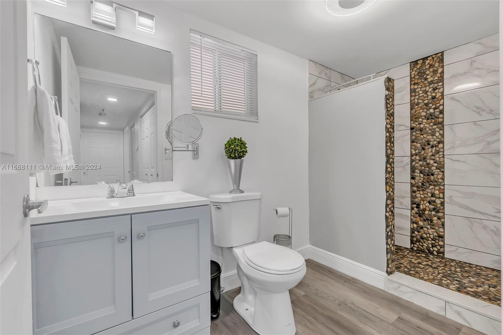 8888 Collins Avenue, Unit 113 Surfside, FL 33154 - Photo 9 of 14 a bathroom with a granite countertop sink toilet and shower