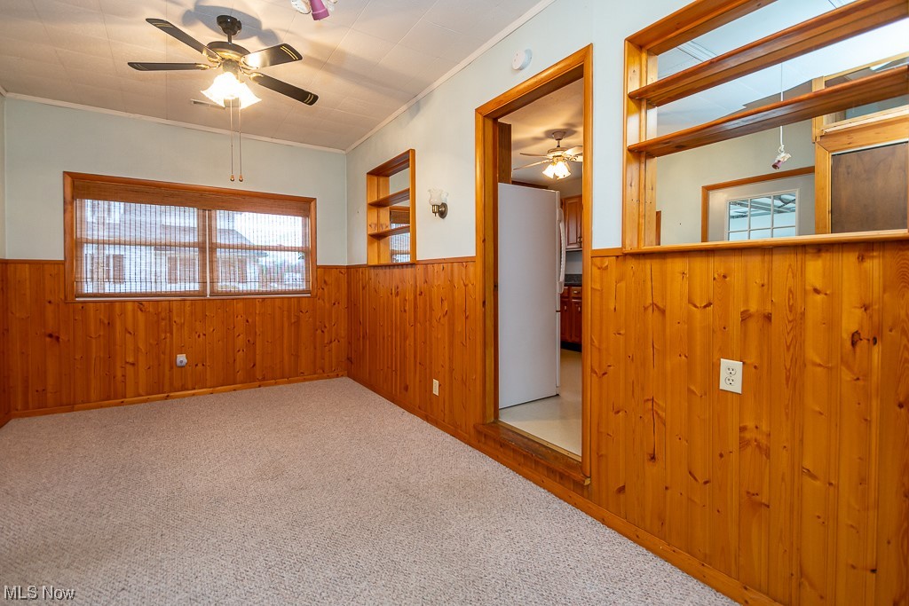 5 Pleasantview Vermilion, OH 44089 - Photo 16 of 37 Spare room with ceiling fan, ornamental molding, a healthy amount of sunlight, and light carpet