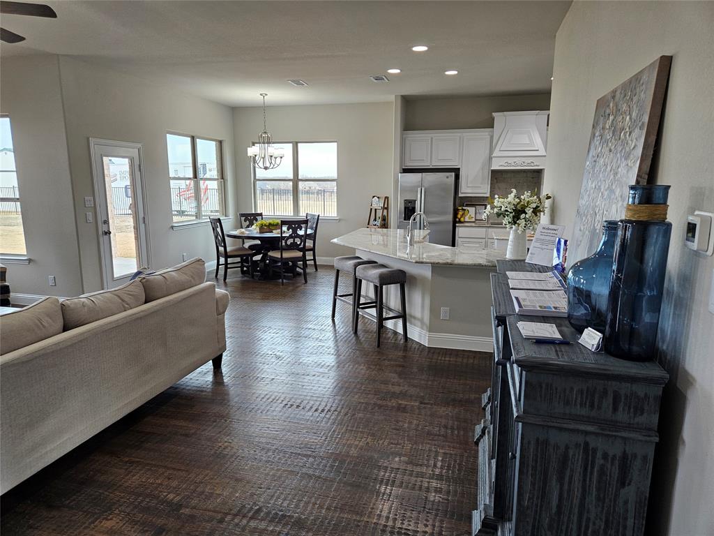 241 Blythe Road Van Alstyne, TX 75495 - Photo 12 of 37 a living room with fireplace furniture and a dining table with wooden floor