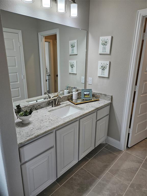 241 Blythe Road Van Alstyne, TX 75495 - Photo 28 of 37 a bathroom with a granite countertop sink and a mirror