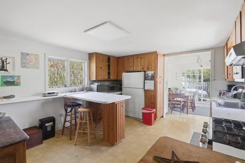 a kitchen with stainless steel appliances a table chairs and a refrigerator