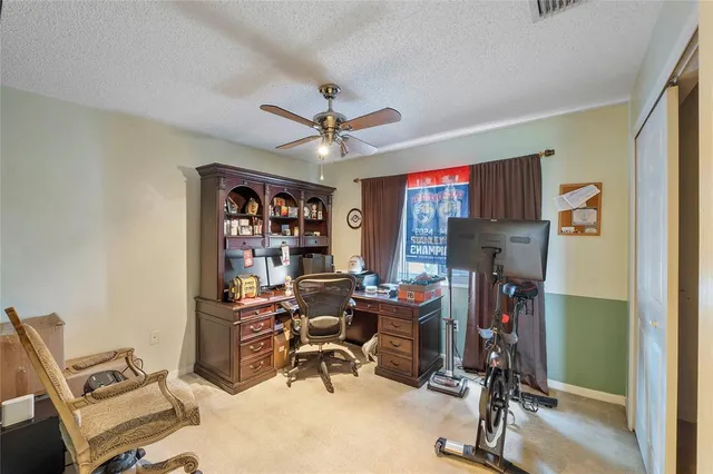 a view of a workspace with furniture and a window