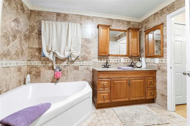 a bathroom with a tub sink and mirror