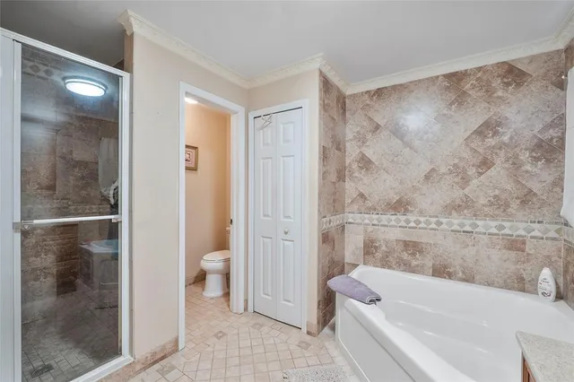 a bathroom with a granite countertop bathtub shower and toilet
