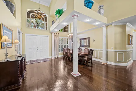 a view of a dining room and livingroom with furniture wooden floor a chandelier