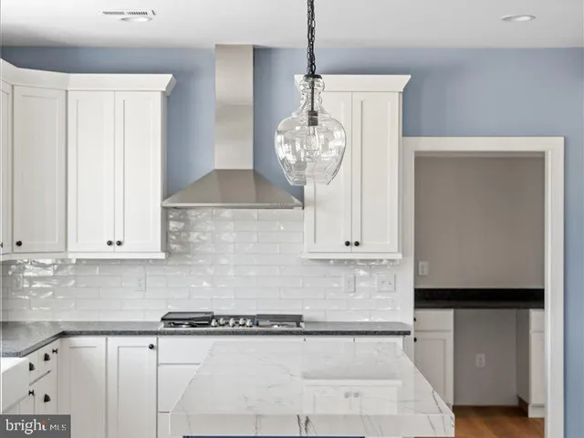 a kitchen with granite countertop a stove and a white cabinet