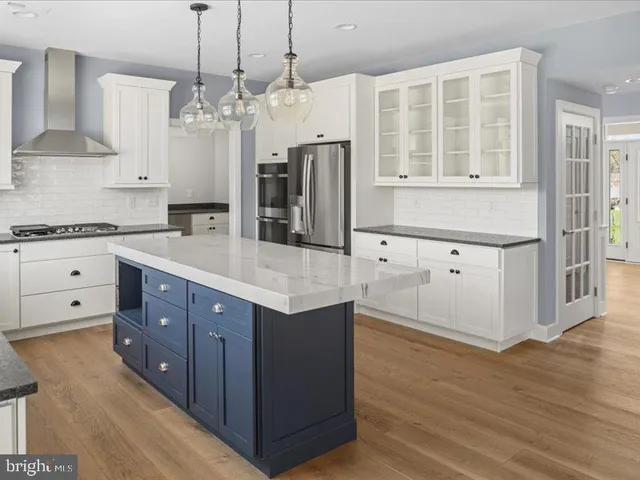 a kitchen with stainless steel appliances granite countertop a refrigerator and a stove