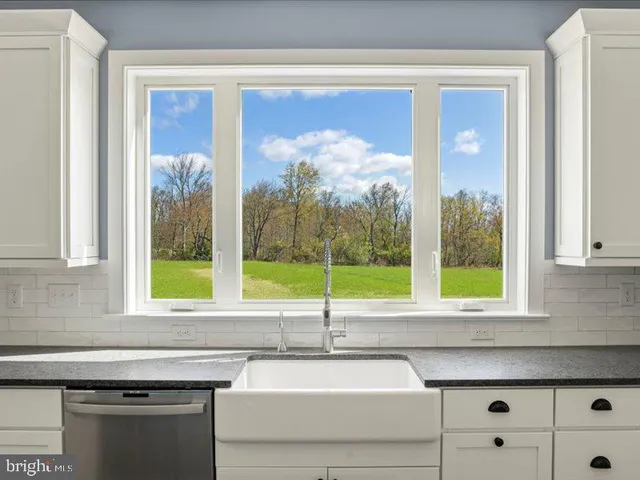 a view of an empty room with a window and a fireplace