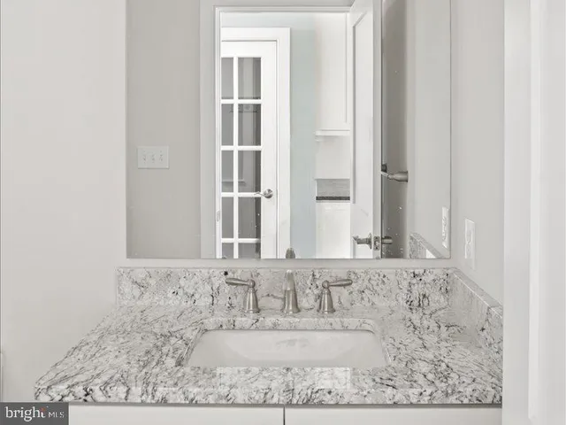 a bathroom with a granite countertop sink a toilet and shower