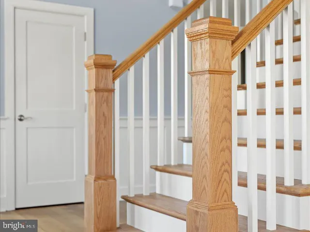 a view of a hallway with wooden floor and staircase