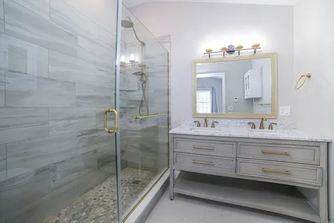 a bathroom with a double vanity sink mirror and shower