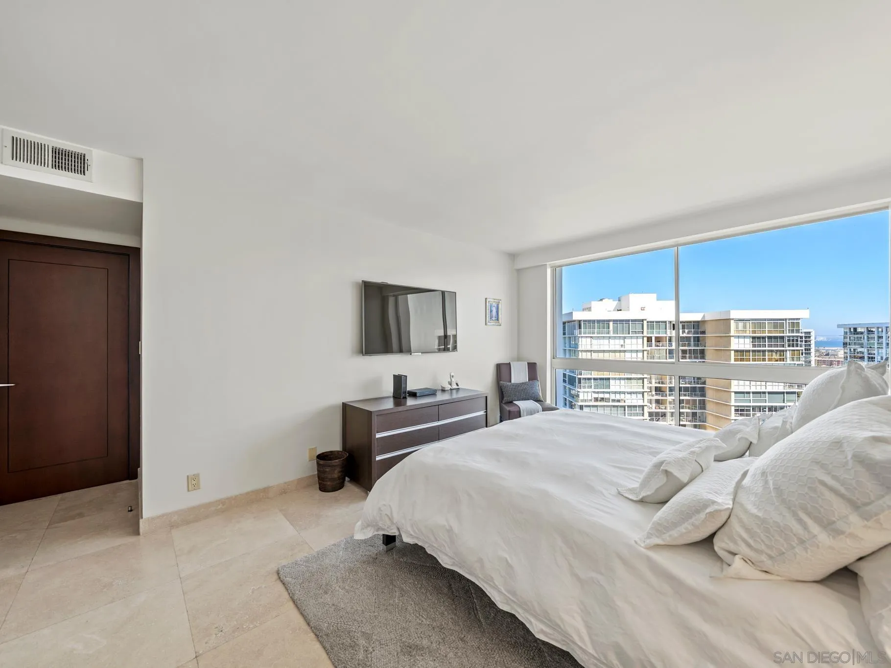 1730 Avenida Del Mundo, Unit 1503 Coronado, CA 92118 - Photo 24 of 47 a bedroom with a bed a flat screen tv and a bookshelf