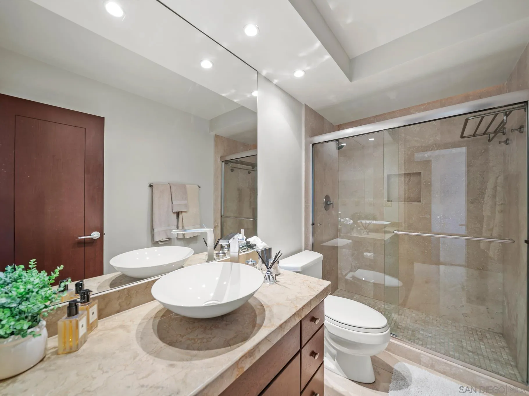 1730 Avenida Del Mundo, Unit 1503 Coronado, CA 92118 - Photo 32 of 47 a bathroom with a granite countertop sink a toilet a mirror and shower