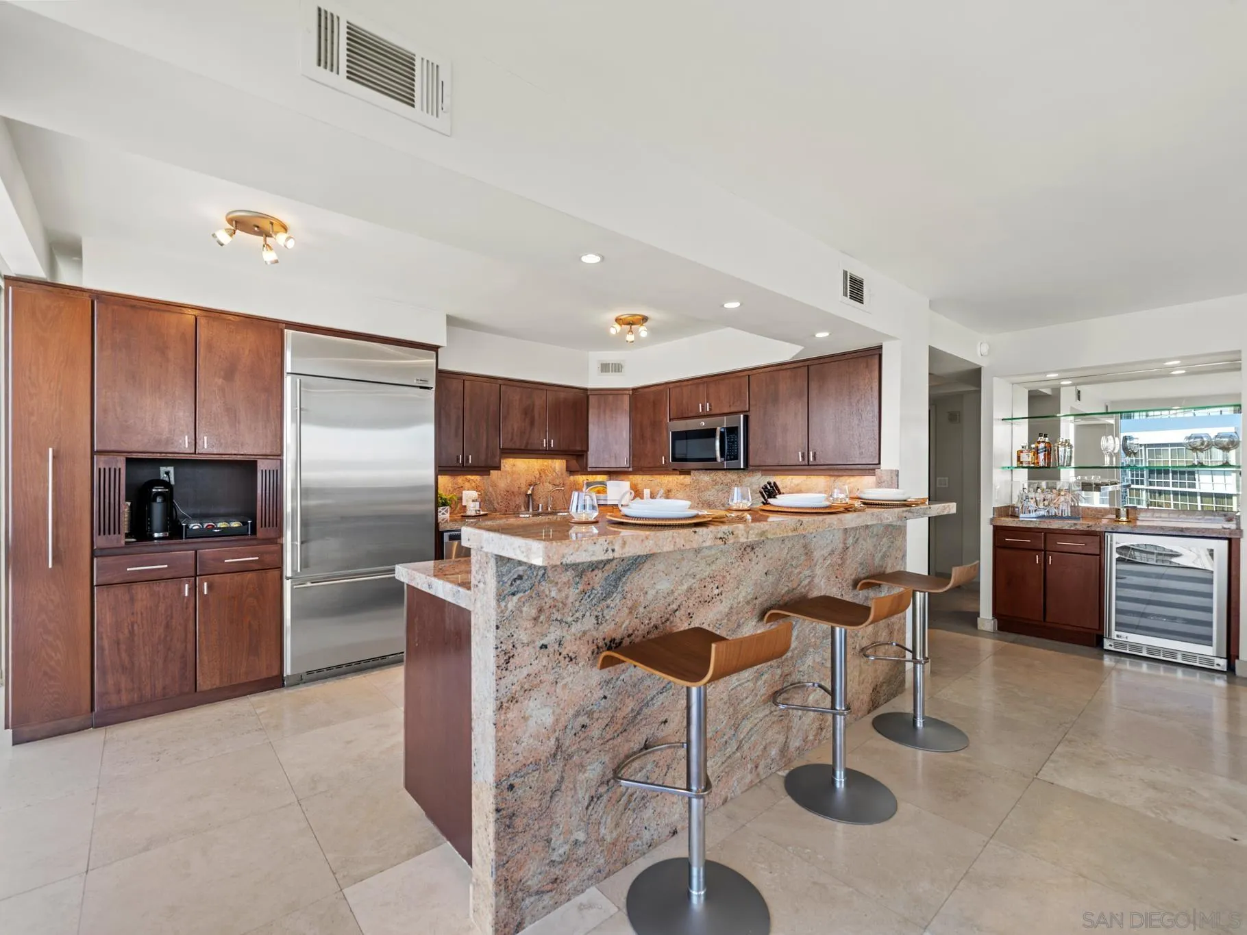 1730 Avenida Del Mundo, Unit 1503 Coronado, CA 92118 - Photo 10 of 47 a kitchen with stainless steel appliances kitchen island granite countertop a table chairs sink and cabinets