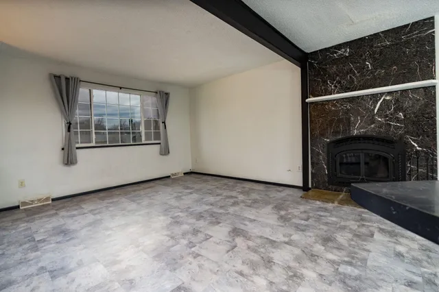 a view of a livingroom with an empty space and a fireplace