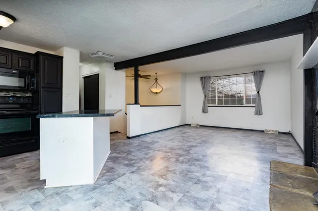 a view of an empty room with a kitchen