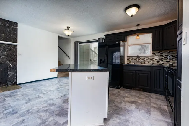 a kitchen with stainless steel appliances granite countertop a stove a sink and a refrigerator