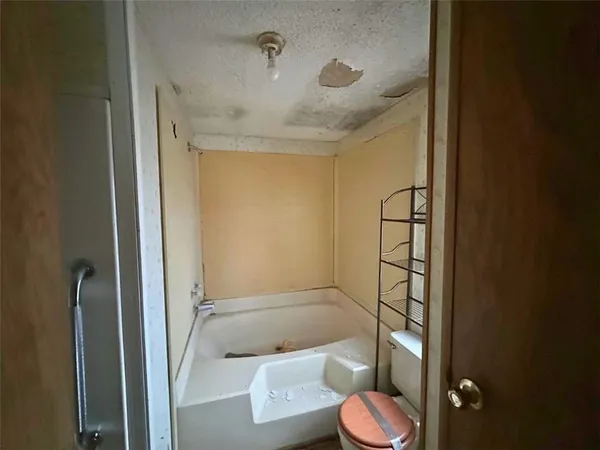 a bathroom with a granite countertop toilet and a shower