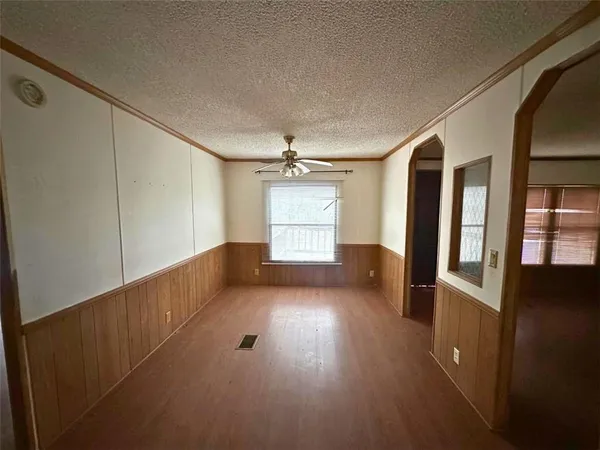 en empty room with wooden floor and windows