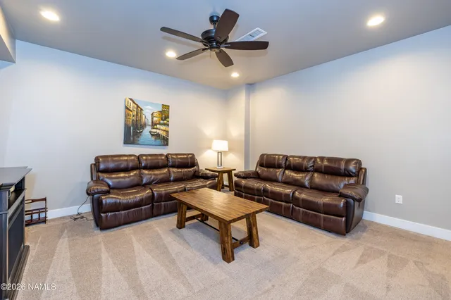 a living room with furniture and a ceiling fan