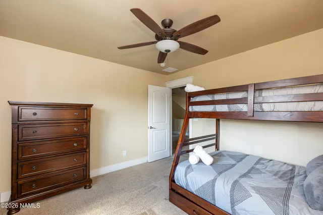 a bed room with a bed and a ceiling fan