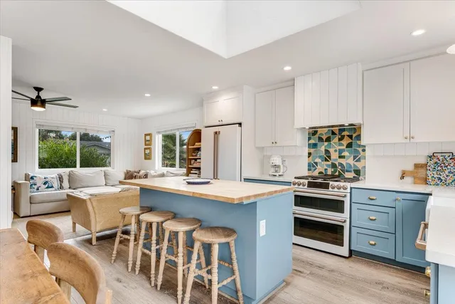a kitchen with stainless steel appliances granite countertop a stove and white cabinets