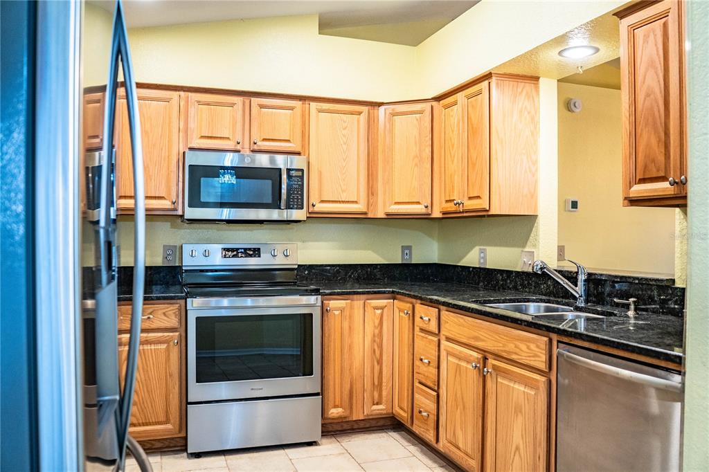 2724 Sundance Place Mulberry, FL 33860 - Photo 12 of 40 a kitchen with stainless steel appliances a stove microwave and sink