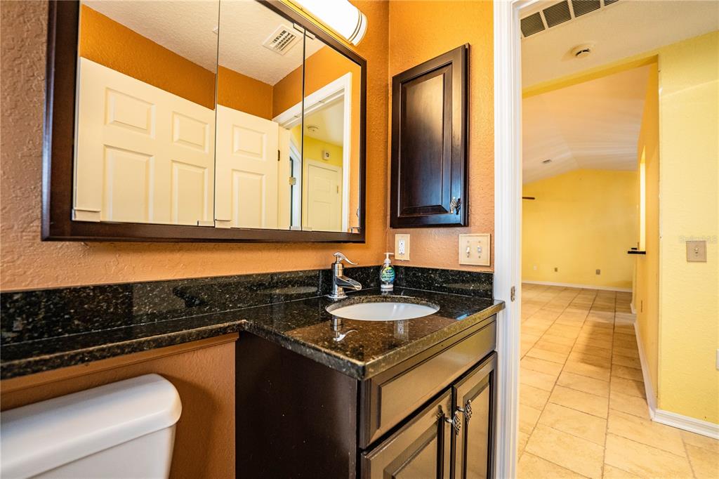 2724 Sundance Place Mulberry, FL 33860 - Photo 25 of 40 a bathroom with a granite countertop sink and a mirror