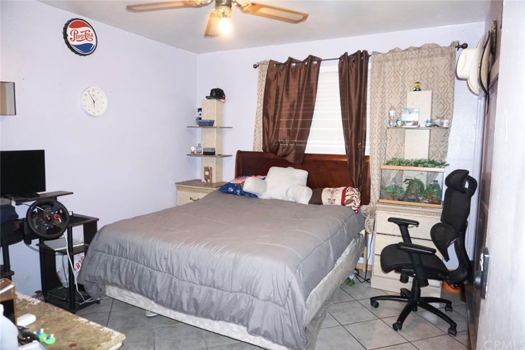 9864 Cedar Avenue Bloomington, CA 92316 - Photo 9 of 15 a bedroom with a bed and a chair